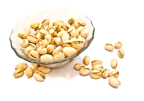 Plate with tasty pistachios on white — Stock Photo, Image