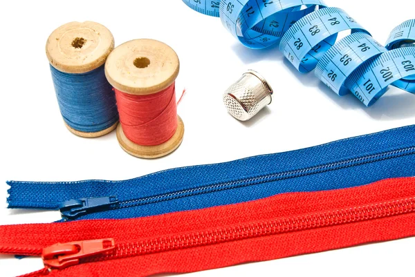 Two zipper, thimble, meter and spools of thread — Stock Photo, Image