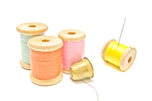 Golden thimble and four spools of thread — Stock Photo, Image