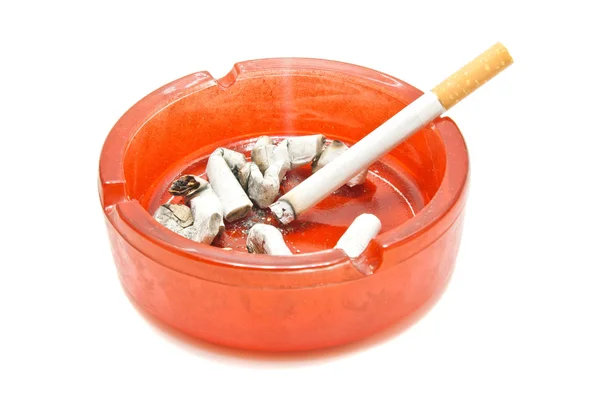 Butts and cigarette in ashtray — Stock Photo, Image