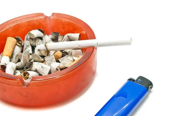 Modrý zapalovač a cigaretu v popelníku — Stock fotografie