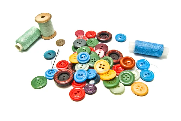 Many plastic buttons and spools of thread — Stock Photo, Image