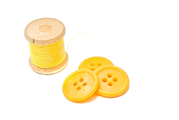 Spool of yellow thread and buttons — Stock Photo, Image