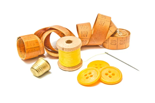 Катушка из желтой нити, наперстка и кнопок — стоковое фото