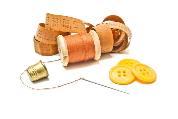 Carretel de linha, dedal e botões em branco — Fotografia de Stock