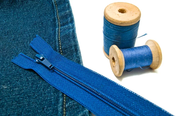 Denim with blue zipper and spools of thread — Stock Photo, Image