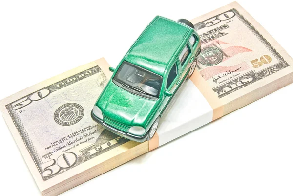 Green car on dollar notes on white — Stock Photo, Image