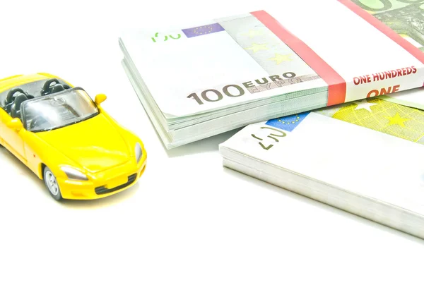 Auto gialla su banconote in euro su bianco — Foto Stock