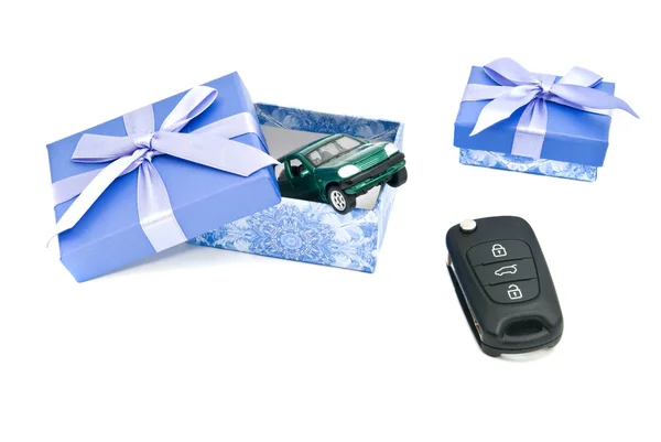 Keys, green car and blue gift boxes — Stock Photo, Image