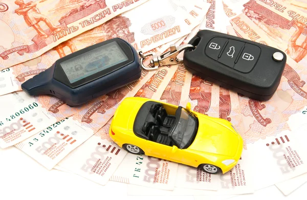 Yellow car, keys and banknotes on white — Stock Photo, Image