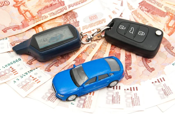 Blue car, keys and banknotes on white — Stock Photo, Image