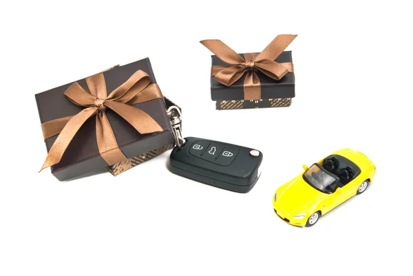 Two brown gift boxes, yellow car and keys — Stock Photo, Image