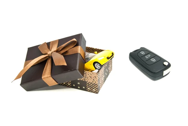 Car keys, yellow car and brown gift box — Stock Photo, Image