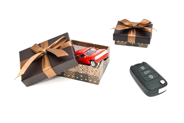 Piros autó, kulcsok és barna díszdobozok — Stock Fotó