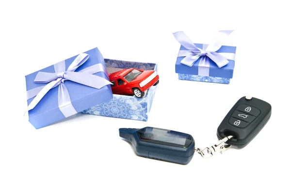 Coche rojo, llaves y cajas de regalo azules — Foto de Stock