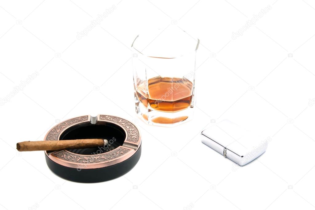 metal lighter, cigarillo in ashtray and whiskey