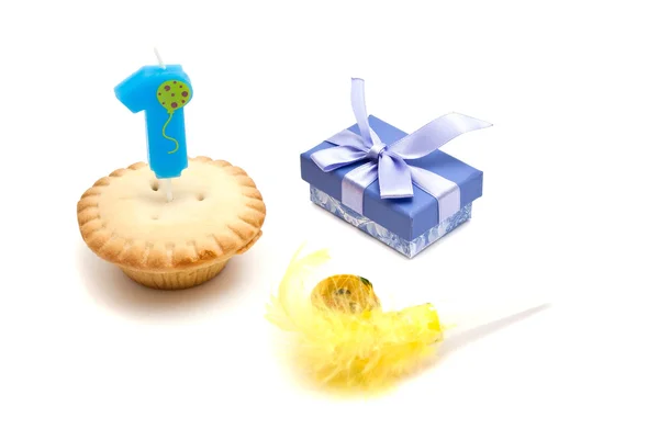 Cupcake with one years birthday candle, gift and whistle — Stock Photo, Image