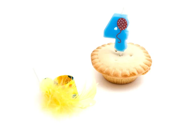 Cupcake com quatro anos de vela de aniversário e apito — Fotografia de Stock