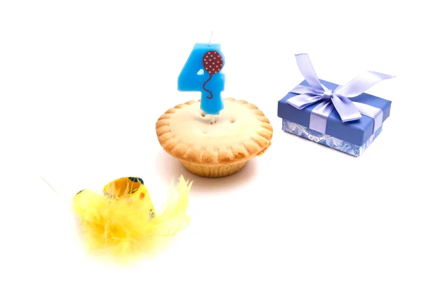Cupcake with four years birthday candle, gift and whistle on whi — Stock Photo, Image