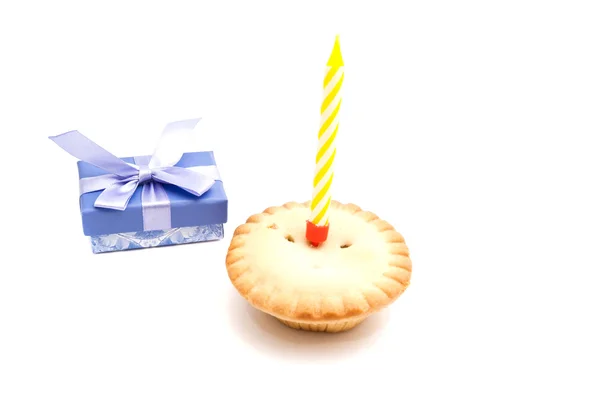 Cupcake with yellow birthday candle and gift — Stock Photo, Image
