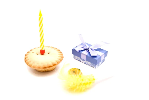 Cupcake com vela de aniversário amarelo, apito e presente — Fotografia de Stock