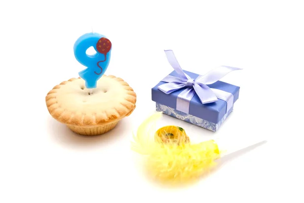 Cupcake with nine years birthday candle, gift and whistle on whi — Stock Photo, Image