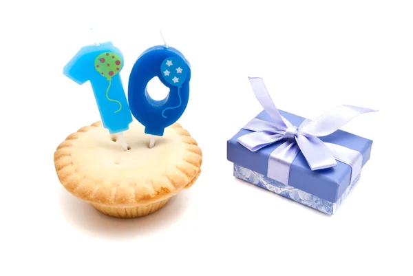 Cupcake com vela de aniversário de dez anos e presente no branco — Fotografia de Stock