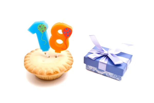 Cupcake with eighteen years birthday candle and gift — Stock Photo, Image