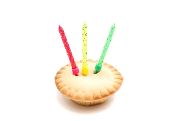 Cupcake with colored birthday candles on white — Stock Photo, Image