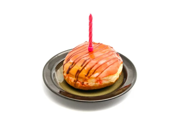 Пончик с розовой свечой на день рождения — стоковое фото