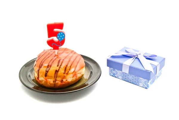 Rosquilla con vela de cumpleaños de cinco años y regalo en blanco — Foto de Stock