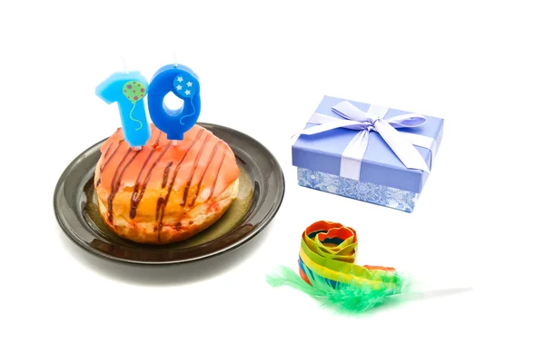 Donut avec dix ans bougie d'anniversaire, sifflet et cadeau — Photo