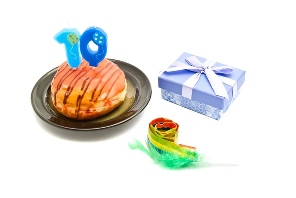 Donut with ten years birthday candle, whistle and gift on white — Stock Photo, Image