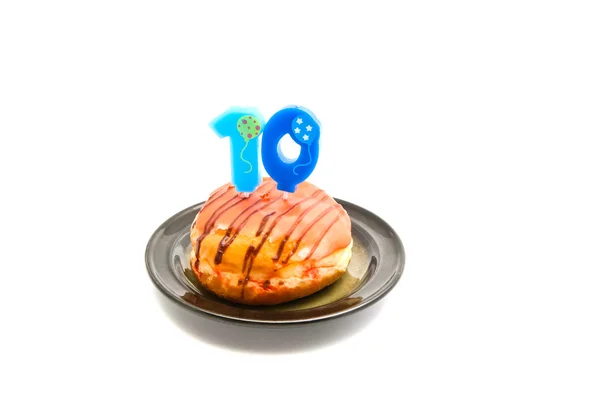 Donut met tien jaar verjaardag kaars op wit — Stockfoto