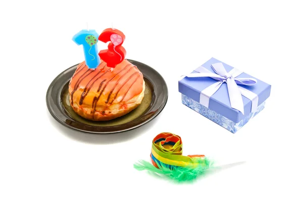 Donut avec treize ans bougie d'anniversaire, sifflet et cadeau — Photo