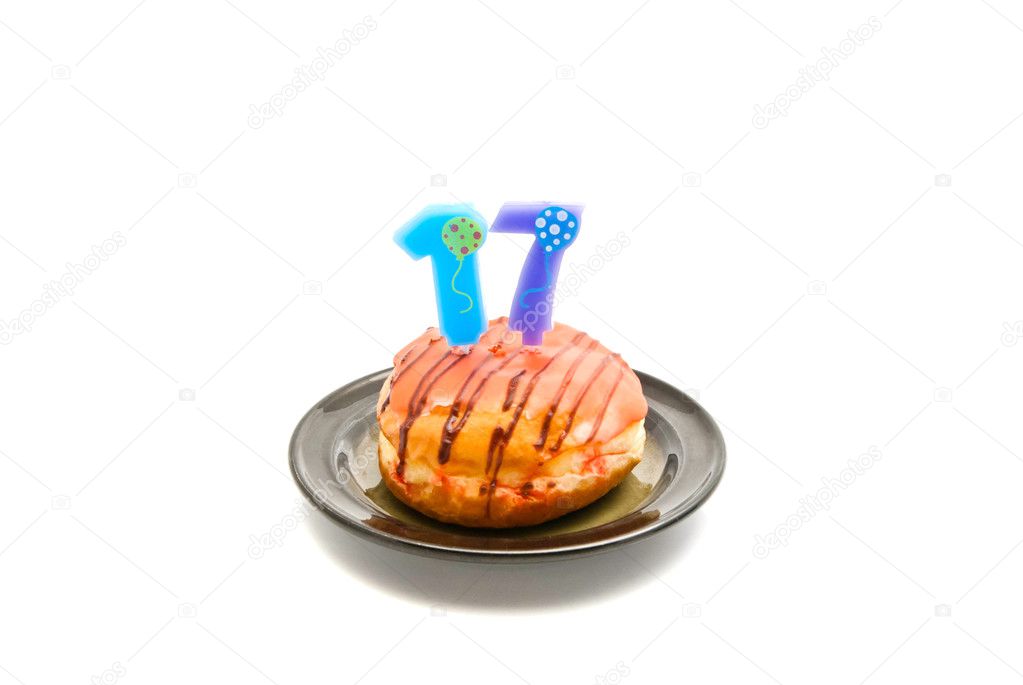 donut with seventeen years birthday candle on white 