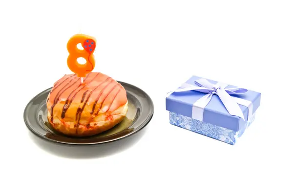 Donut met acht jaar verjaardag kaars en cadeau — Stockfoto