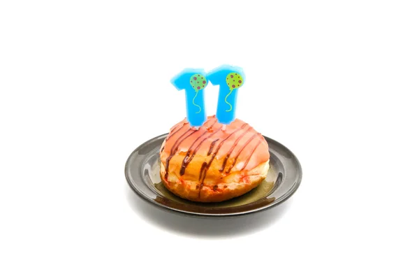 Donut met elf jaar verjaardag kaars op wit — Stockfoto