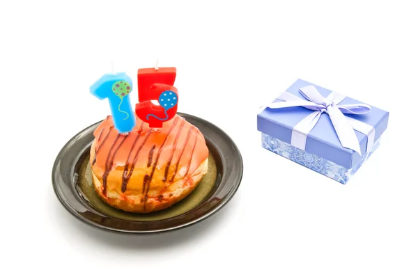 Donut with fifteen years birthday candle and gift — Stock Photo, Image