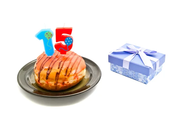 Donut with fifteen years birthday candle and gift on white — Stock Photo, Image