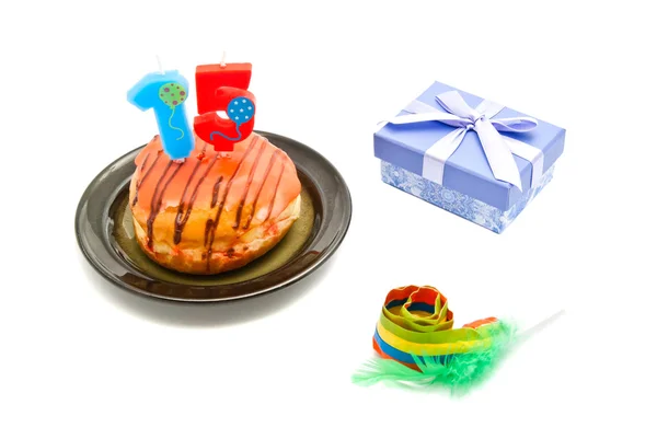 Donut with fifteen years birthday candle, whistle and gift on wh — Stock Photo, Image