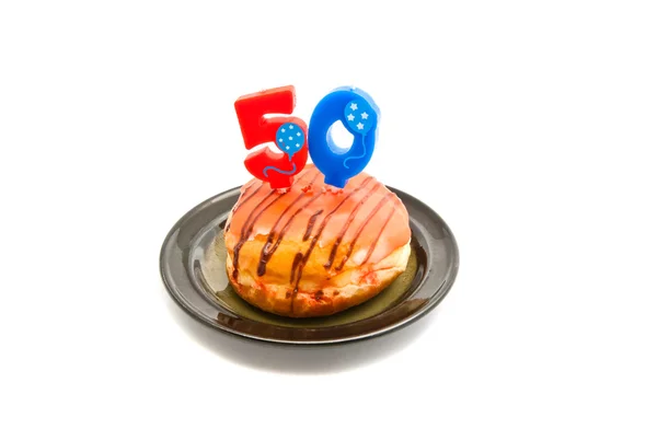 Donut with fifty years birthday candle on white — Stock Photo, Image