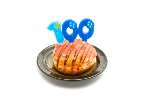 Donut with one hundred years birthday candle on white — Stock Photo, Image