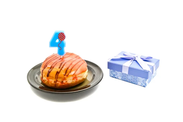 Donut with four years birthday candle and gift — Stock Photo, Image