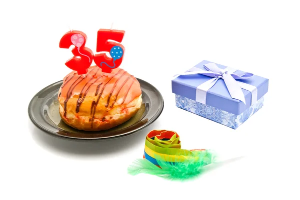 Пончик с тридцатипятилетней свечи дня рождения, свисток и подарок — стоковое фото