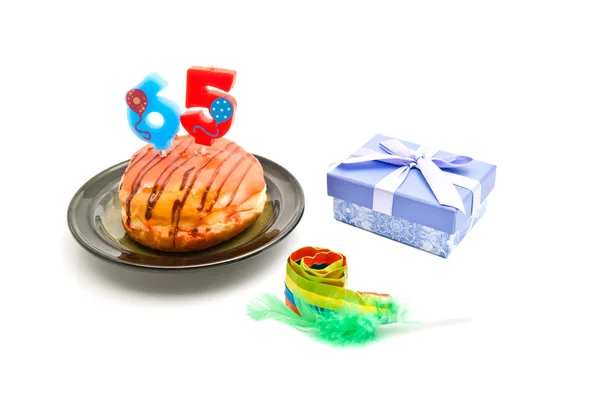 Donut with sixty five years birthday candle, whistle and gift — Stock Photo, Image