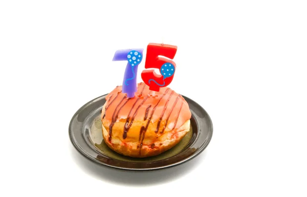 Donut with seventy five years birthday candle on white — Stock Photo, Image