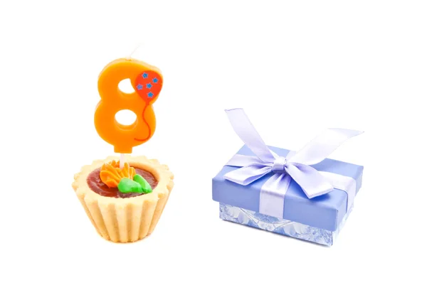 Торт с восьмилетней свечи дня рождения и подарок на белом — стоковое фото