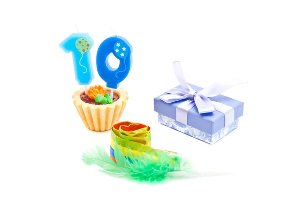 Cake with ten years birthday candle, whistle and gift on white — Stock Photo, Image