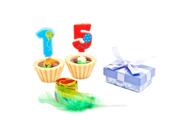 Cakes with fifteen years birthday candles, whistle and gift on w — Stock Photo, Image